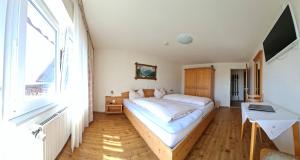 Gasthaus zum Kreuz في غرافنهاوسن: غرفة نوم بها سرير ونافذة كبيرة