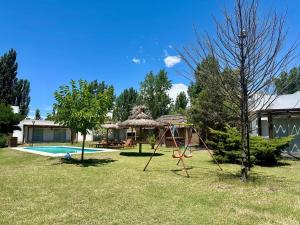 a yard with a swing and a pool at Complejo de Cabaña con pileta CABLE A TIERRA Cabaña Blend in San Rafael