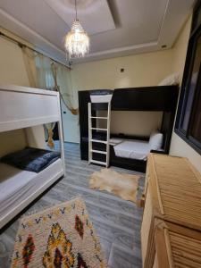een kamer met 2 stapelbedden en een tapijt bij Breeze surf lodge in Tamraght Ouzdar