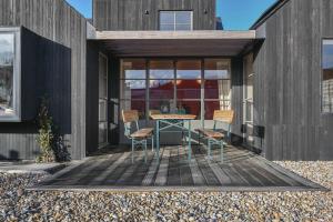 een houten terras met een tafel en stoelen erop bij Luna in Camber