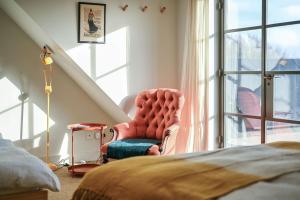 een slaapkamer met een rode stoel en een raam bij Luna in Camber