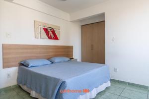 a bedroom with a large bed with blue pillows at Apartamento em Macae no Centro da Cidade in Imbetiba