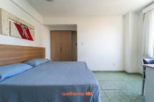 a bedroom with a bed with a blue comforter at Apartamento em Macae no Centro da Cidade in Imbetiba