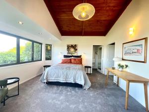 a bedroom with a bed and a wooden ceiling at Iconic Taupō Views in Taupo +14 photos