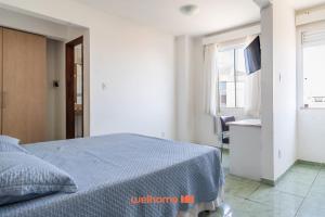 a bedroom with a bed with a blue blanket at Apartamento em Macae no Centro da Cidade in Imbetiba +4 photos