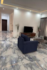 un soggiorno con divano e TV su un pavimento in marmo di Eliana Castle a Trofwi