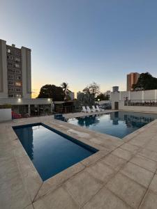 Una gran piscina con sillas y un edificio. en Apt Vista Mar Completo próx Praias da litoranea, en São Luís