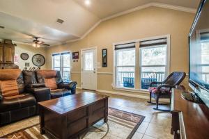 een woonkamer met een bank en een tafel bij River View on the Guadalupe - Riverfront with Large Deck & Cliff Side Views in New Braunfels