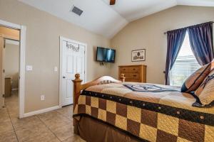 een slaapkamer met een bed, een tv en een raam bij River View on the Guadalupe - Riverfront with Large Deck & Cliff Side Views in New Braunfels