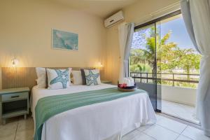 ein Schlafzimmer mit einem Bett und einem großen Fenster in der Unterkunft Pousada Barra Mar in Barra de Ibiraquera + 64 Fotos