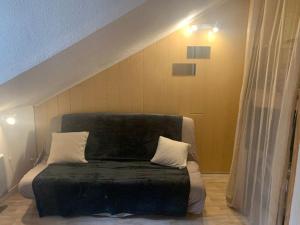 un letto con due cuscini sopra in una stanza di Le grand duc17 a Cauterets