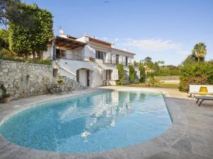 a swimming pool in front of a house at Villa Roxane in Vallauris