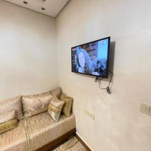 a living room with a couch and a flat screen tv at Prime stay downtown Meknes in Meknès