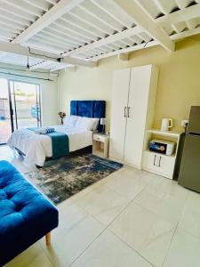 a bedroom with a bed and a blue couch at Enez Place in Gqeberha