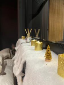 Una mesa con adornos navideños dorados. en L'élégance - Charme - Jacuzzi - -Secret- Parking, en Sarrebourg