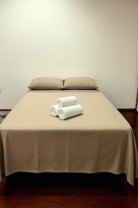 ウベルランジアにあるStudio Privativo 4 min Hospital St Marta, Praia Clube e Centroのベッドの上に座るタオル2枚