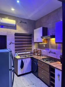 una cocina con fregadero y estufa horno superior en The Private Pearl Apartment, en Ikeja