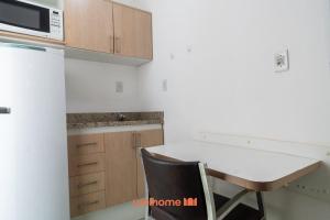 een keuken met een aanrecht, een tafel en een magnetron bij Apartamento em Macae Proximo a Praia do Farol in Imbetiba