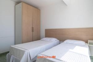 een slaapkamer met 2 bedden en een kast bij Apartamento em Macae Proximo a Praia do Farol in Imbetiba