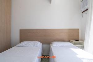 een slaapkamer met 2 bedden en een hoofdeinde bij Apartamento em Macae Proximo a Praia do Farol in Imbetiba +7 foto's