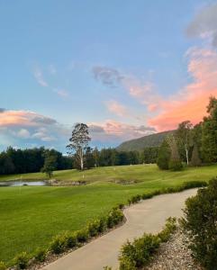 a view of a golf course with a tree in the distance at The Tailor's Cottage Kangaroo Valley in Kangaroo Valley