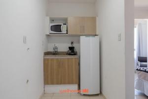 eine kleine Küche mit Kühlschrank und Mikrowelle in der Unterkunft Apto no Centro de Macae a 550m da Praia do Farol in Imbetiba + 6 Fotos