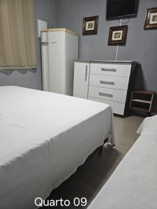 Pousada Santo Agostinho في إكستريما: غرفة نوم بسرير ابيض وثلاجة +104 صور