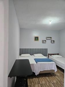 Pousada Santo Agostinho في إكستريما: غرفة نوم بسريرين وطاولة فيها