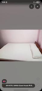 ein weißes Bett in einem Raum mit Avertisation für in der Unterkunft Sri Hotel Ganga Couple&Family Friendly in Patna + 5 Fotos