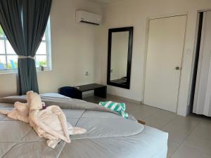 Un animal de toalla sentado al final de una cama. en Villa Fina Aruba, en Palm-Eagle Beach