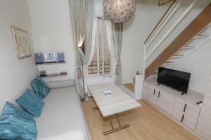 a living room with a couch and a television at Loft Moderne - À Deux Pas de Monte-Carlo in Roquebrune-Cap-Martin