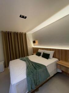 ウバジャラにあるPousada Na Serra Ubajaraのベッドルーム(白い大型ベッド、黒い枕付)