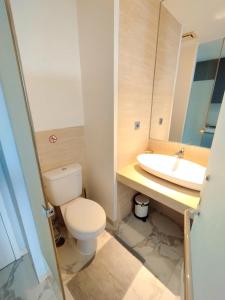 a bathroom with a toilet and a sink at Art Deco Lux Apartment with Mountain View in Bandung +18 photos