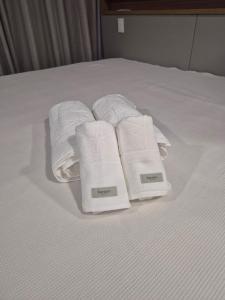 a group of towels sitting on top of a bed at STÚDIO 017 - Novo e Sofisticado! in Princesa dʼOeste