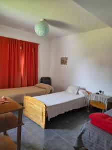 ein Schlafzimmer mit zwei Betten und einem roten Vorhang in der Unterkunft Complejo "El Padrino" in Villa Carlos Paz