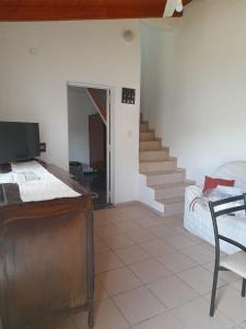 ein Wohnzimmer mit einem Bett und einer Treppe in der Unterkunft Complejo "El Padrino" in Villa Carlos Paz