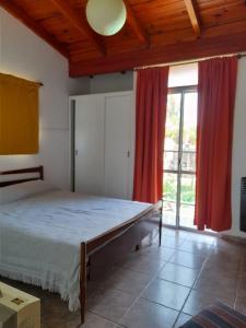 ein Schlafzimmer mit einem Bett und einem großen Fenster in der Unterkunft Complejo "El Padrino" in Villa Carlos Paz + 20 Fotos