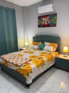 a bedroom with a bed with a floral bedspread at Alojamiento en Ayangue in Santa Elena