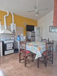 eine Küche mit einem Tisch, 2 Stühlen und einem Herd in der Unterkunft Complejo "El Padrino" in Villa Carlos Paz