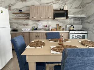 cocina con mesa con sillas y nevera blanca en Villa Fina Aruba, en Palm-Eagle Beach