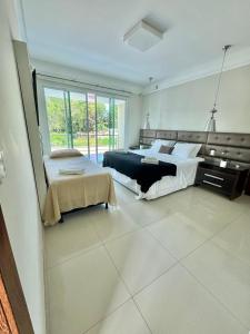 a large bedroom with two beds and a large window at Casa Fênix in Porto Seguro