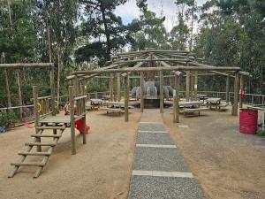 um parque infantil com um pavilhão de madeira e um escorrega em Parque Mar Depto em El Tabo