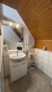 HTS Mosel Apartment Wanderlust Bernkastel Andel في بيرنكاستل كويز: حمام مع حوض أبيض وسقف خشبي