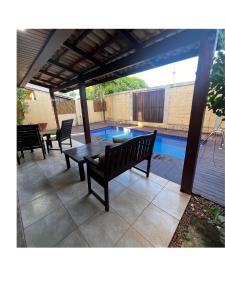 Suíte Beleza Pura V11- B في بيبا: فناء مع طاولة وكراسي وحمام سباحة