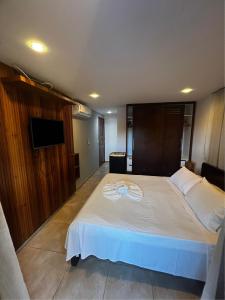 Suíte Beleza Pura V11- B في بيبا: غرفة نوم بها سرير كبير وتلفزيون بشاشة مسطحة