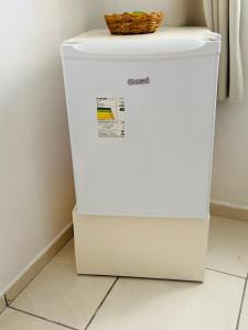 a white refrigerator with a basket on top of it at Fonte dos Corais - Suíte Onda do Mar in Maragogi
