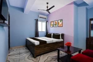 een slaapkamer met een bed met blauwe muren en een tafel bij Hotel O Deendayal Crossway Ranchi Formerly Yashoda in Rānchī