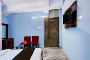 een slaapkamer met een bed en een flatscreen-tv bij Hotel O Deendayal Crossway Ranchi Formerly Yashoda in Rānchī +16 foto's