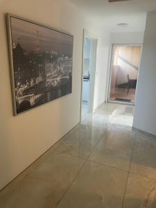 Una sala de estar con un cuadro en la pared y piso de baldosas. en Sunshine FeWo, en Rust