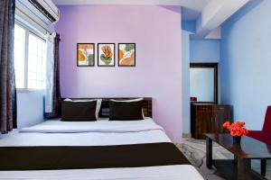 een slaapkamer met een bed en een blauwe muur bij Hotel O Deendayal Crossway Ranchi Formerly Yashoda in Rānchī